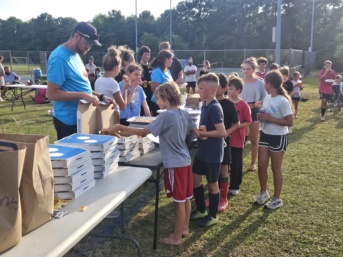Falcons United players and families sharing food at a club community event